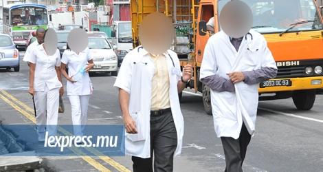 Des médecins, avec leur stéthoscope, et des infirmières se baladant en uniforme dans la rue. Cette pratique augmente les risques de propager les infections des patients.