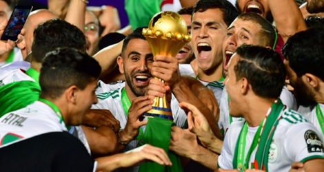L'attaquant Riyad Mahrez (c) soulève le trophée après la victoire de l'équipe d'Algérie contre le Sénégal en finale de la CAN-2019, le 19 juillet 2019 au Caire.
