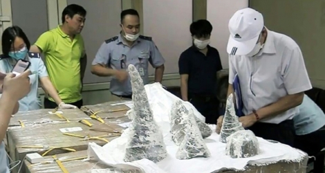 Des agents des douanes de l'aéroport international de Noi Bai sortent des morceaux de cornes de rhinocéros de leur emballage à Hanoi, le 25 juillet 2019.