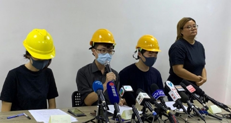 Trois membres du mouvement pro-démocratie hongkongais portant un masque donnent une conférence de presse «par le peuple, pour le peuple», à Hong Kong le 6 août 2019.