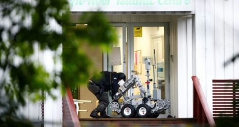Un policier norvégien manipule un robot après la fusillade dans un mosquée près d'Oslo, à Baerum, le 10 août 2019.