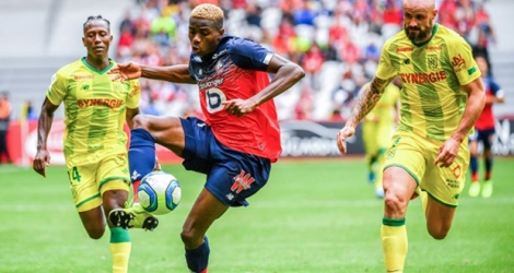 L'attaquant nigérian de Lille, Victor Osimhen (c), à la lutte avec le défenseur de Nantes, Nicolas Pallois, lors du match de Ligue 1 à Villeneuve-d'Ascq, le 11 août 2019.