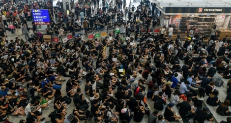 Des manifestants prodémocratie bloquent les accès aux portes d'embarquement, le 13 août 2019 à l'aéroport de Hong Kong.