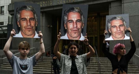 Des manifestants portent des photos de Jeffrey Epstein le 8 juillet 2019 devant la prison de New York où était emprisonné Jeffrey Epstein avant son suicide.