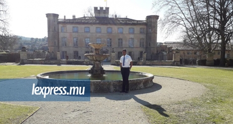 Jean West Azie posant devant le Château Beaulieu, en France, où il est employé en tant que majordome depuis 2017.