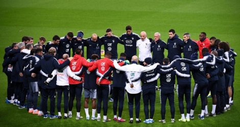 Les joueurs et l'encadrement de l'équipe de France de football respectent une minute de silence sur la pelouse du Stade de France le 13 novembre 2019, en hommage aux victimes des attentats du 13 novembre 2015 à Paris et Saint-Denis.
