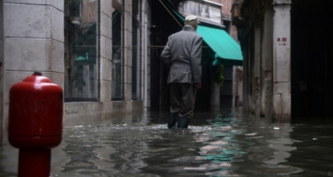 Un homme marche dans une rue inondée de Venise le 17 novembre 2019.