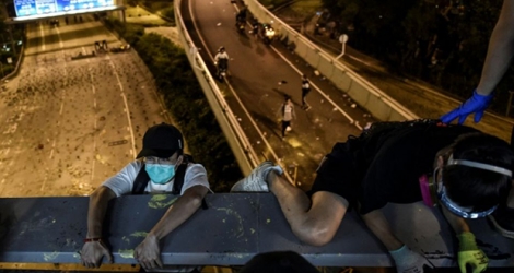 Des manifestants hongkongais assiégés par la police dans un campus s'enfuient le 18 novembre 2019.