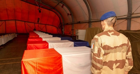 Un soldat français devant les cercueils des 13 militaires de la Force Barkahne morts dans un accident d'hélicoptère, à Gao (Mali), le 27 novembre 2019 (photo du Sirpa, Service d'information et de relations publiques des armées).