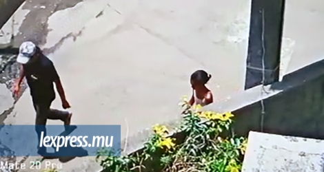 Une image CCTV montrant le suspect en compagnie de la fillette, qui le suit à quelques pas.