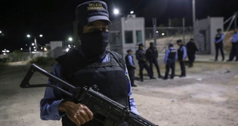 Des membres de la police nationale du Honduras patrouillent devant l'entrée de la prison de El Porvenir après les affrontements qui ont fait au moins 18 morts, le 22 décembre 2019.