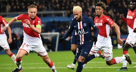 La star du PSG Neymar (c) tente d'échapper au défenseur polonais de Monaco Kamil Glik (g), le 12 janvier 2020 au Parc des Princes.