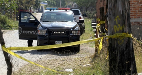 Des véhicules de police près d'une fosse commune découverte dans la municipalité de Tlajomulco, près de Guadalajara, le 13 janvier 2020 au Mexique.