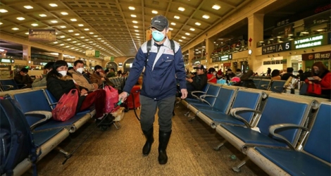 Un agent d'entretien passe du désinfectant à la gare Hankou de Wuhan, en Chine, hier.