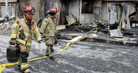 Des pompiers péruviens sur le site de l'explosion d'un camion transportant du gaz à Lima le 23 janvier 2020.