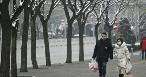 Des personnes, équipées de masques de protection, marchent dans une rue de Pékin, le 2 février 2020 Photo WANG Zhao. AFP 
