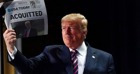 Le président américain Donald Trump montre un exemplaire du quotidien USA Today au lendemain de son acquittement par le Sénat, le 6 février 2020 à Washington.