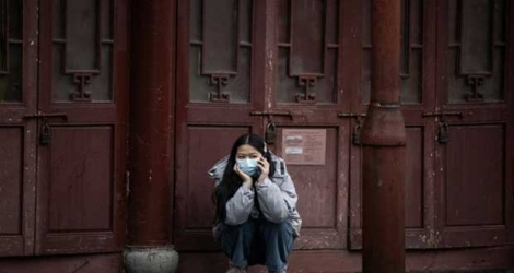 Une femme téléphone, le visage couvert d'un masque de protection, à Shanghai le 11 février 2020.