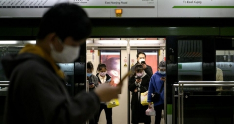 Des passagers dans le métro de Shanghai, le visage couvert d'un masque de protection, le 25 février 2020.