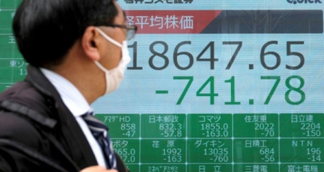 Un tableau électronique affiche le recul des cours à la Bourse de Tokyo, le 30 mars 2020.