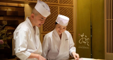 Mizuho Iwai (d) apprend auprès d'un maitre sushi dans le restaurant Onodera à Tokyo, le 27 novembre 2019 la façon de préparer le poisson.