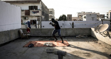 Le lutteur sénégalais s'entraîne sur le toit d'un immeuble de Dakar le 15 avril 2020.