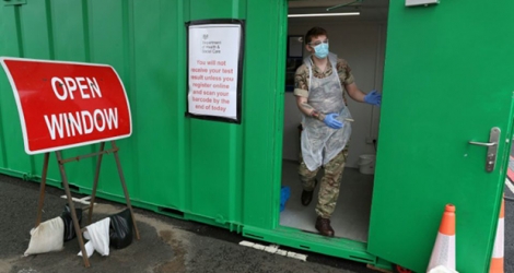 Un militaire s'apprête à réaliser des prélèvement de test au coronavirus en «drive» à l'aéroport de Glasgow le 29 avril 2020.