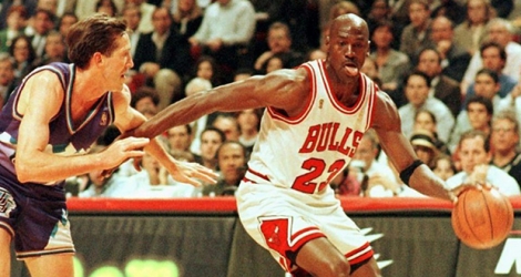 Michael Jordan dans son attitude caractéristique, toute langue dehors, sous le maillot des Chicago Bulls en un contre-un devant Jeff Hornacek des Utah Jazz en finale NBA le 4 jui 1997 à Chicago.