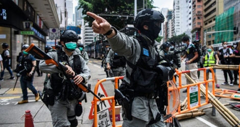 Les forces de police nettoient les rues après un rassemblement en faveur de la démocratie, à Hong Kong le 24 mai 2020.
