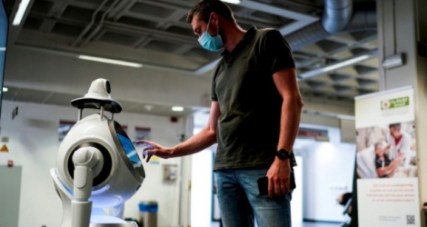 Un employé de l'entreprise belge ZoraBots teste un robot appelé CRUZR, le 29 mai 2020 à l'hôpital d'Anvers Photo Kenzo TRIBOUILLARD. AFP