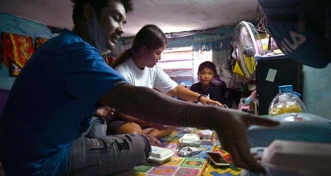 La famille Noidee, durement touchée par le confinement dû au coronavirus, partage un repas fourni par l'aide alimentaire, le 28 mai 2020 à Bangkok.