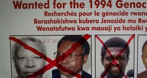 Une croix rouge barre les photos de Félicien Kabuga sur un avis de recherche au siège de l'Unité de suivi des fugitifs du génocide, le 22 mai 2020 à Kigali, après son arrestation en France.