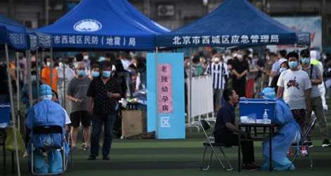 Des Chinois qui ont fréquenté le marché Xinfadi ou qui vivent à proximité se font tester au coronavirus dans un stade de Pékin, le 14 juin 2020.