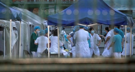 Des soignants effectuent des tests au coronavirus au centre sportif de Dongdan à Pékin.