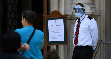 Un garde masqué à l'entrée de la cathédrale de Westminster à Londres le 5 juillet 2020. 