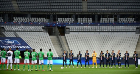 Les joueurs du Paris Saint-Germain et de Saint-Etienne durant la minute d'applaudissements en mémoire des victimes du Covid-19 avant la finale de la Coupe de France de football dans un stade avec peu de spectateurs le 24 juillet 2020 à Saint-Denis.