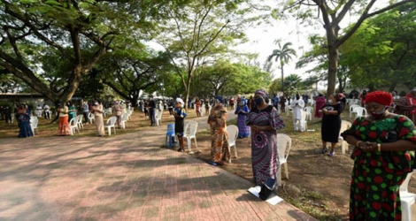 Des fidèles portant des masques assistent à une messe devant une église catholique de Lagos le 9 août 2020 après la levée par le gouvernement de l'interdiction des cérémonies religieuses.