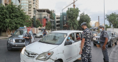 Des membres des forces de sécurité libanaises contrôlent les automobilistes au premier jour du reconfinement pour lutter contre la pandémie de coronavirus, le 21 août 2020 à Beyrouth.