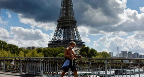 Un marcheur passe devant la tour Eiffel à Paris le 28 août 2020.