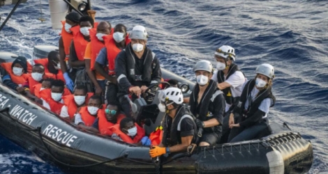 Des migrants du bateau Louise Michel, affrété par l'artiste de rue Banksy, sont emmenés par des membres d'équipage du bateau humanitaire Sea-Watch 4 lors d'une opération de secours, le 29 août 2020 au large des côtes maltaises Photo Thomas Lohnes. AFP