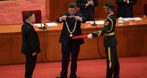 Zhang Boli (G), expert en médecine traditionnelle chinoise, reçoit une récompense des mains du président Xi Jinping (C) lors d'une cérémonie à Pékin en honneur de ceux qui ont lutté contre la pandémie de Covid-19, le 8 septembre 2020.