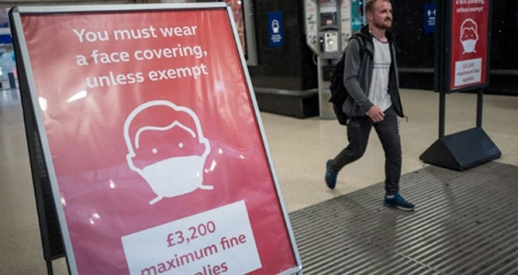 Une affiche incite les passagers des transports en commun à porter un masque, dans la gare de Victoria à Londres, le 23 septembre 2020.