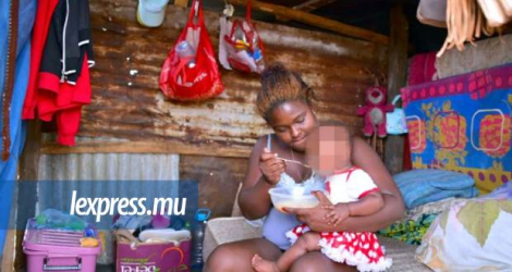Cette jeune mère donne des nouilles instantanées à son enfant. Photo prise hier de Felicia, qui est parmi les squatters de Pointe-aux-Sables.