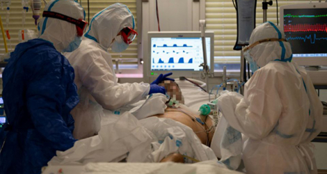 Des soignants en combinaison intégrale de protection s'occupent d'un patient atteint du coronavirus dans l'unité de soins intensifs de l'hôpital universitaire Severo Ochoa, le 16 octobre 2020 à Leganés, dans la banlieue de Madrid.