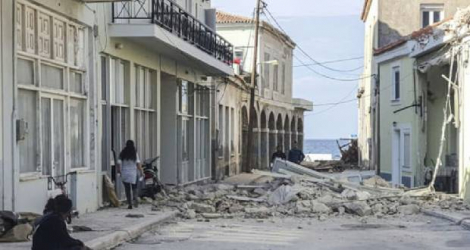 Des habitants près d'une maison détruite par un séisme sur l'île de Samos (Grèce), le 30 octobre 2020 Photo STR. AFP