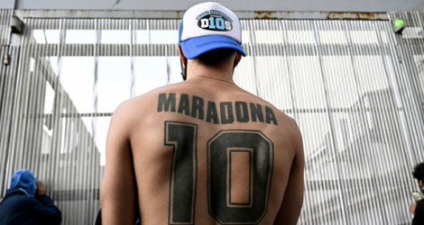 Un supporter de Diego Mardona affiche ses tatouages à la gloire de son idole devant l'hôpital où a été opéré l'ancien joueur, le 3 novembre 2020 à Olivos, près de Buenos Aires.