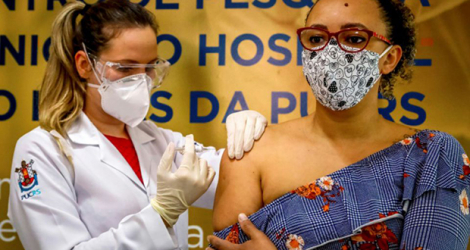 Une volontaire (d) reçoit le candidat vaccin du laboratoire chinois Sinovac Biotech, à Porto Alegre (sud du Brésil), le 8 août 2020. [Photo SILVIO AVILA. AFP]