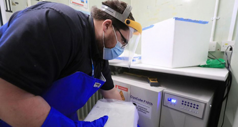 Un technicien pharmaceutique livre les précieux vaccins dans des armoires réfrigérées à Croydon.  