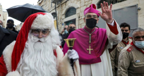 L'archevêque Pierbattista Pizzaballa, du patriarcat latin de Jérusalem, salue la foule lors de traditionnelle procession de Noël dans les rues de Bethléem, en Cisjordanie occupée, le 24 décembre 2020 Photo HAZEM BADER. AFP