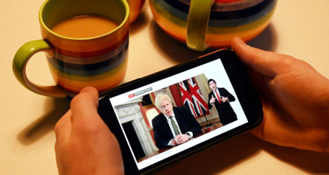 Sur un écran de téléphone portable, le Premier ministre britannique Boris Johnson annonce le nouveau confinement, à Londres, le 4 janvier 2020.